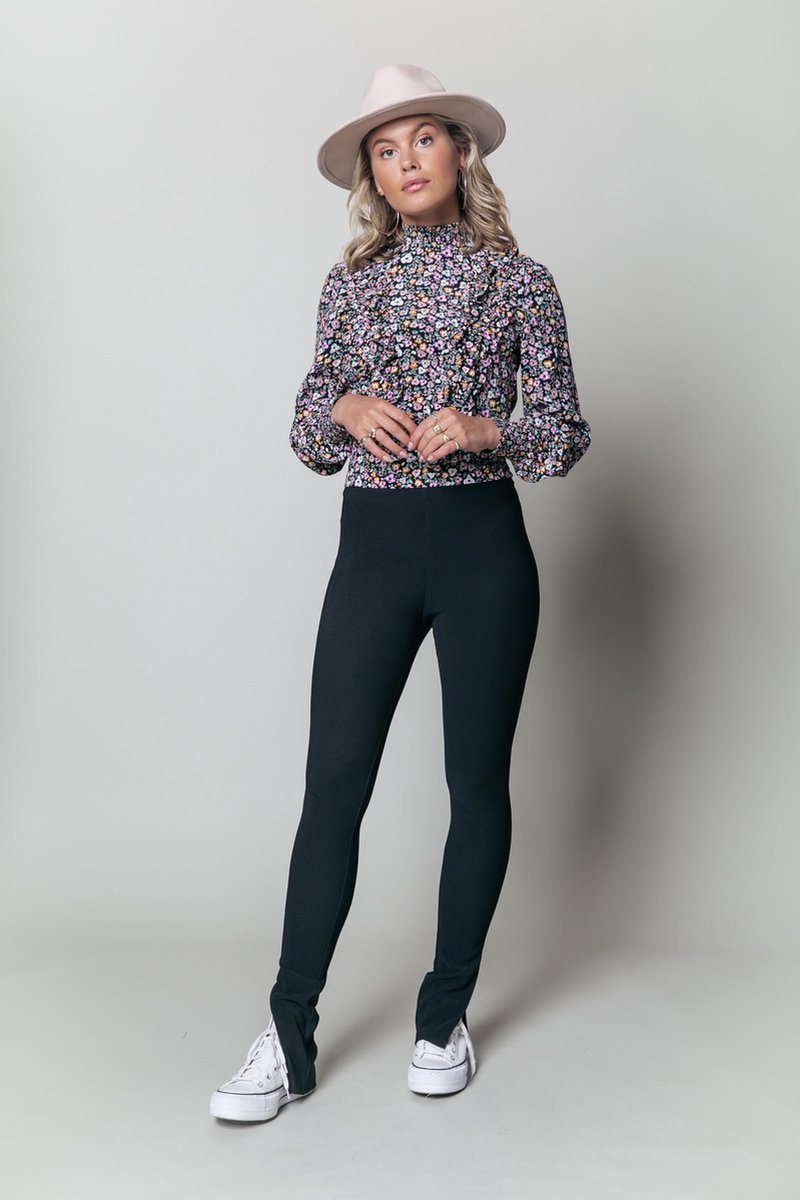 bloemenprint, blouse met hoge kraag, donkeren broek, fedora hoed, casual sneakers