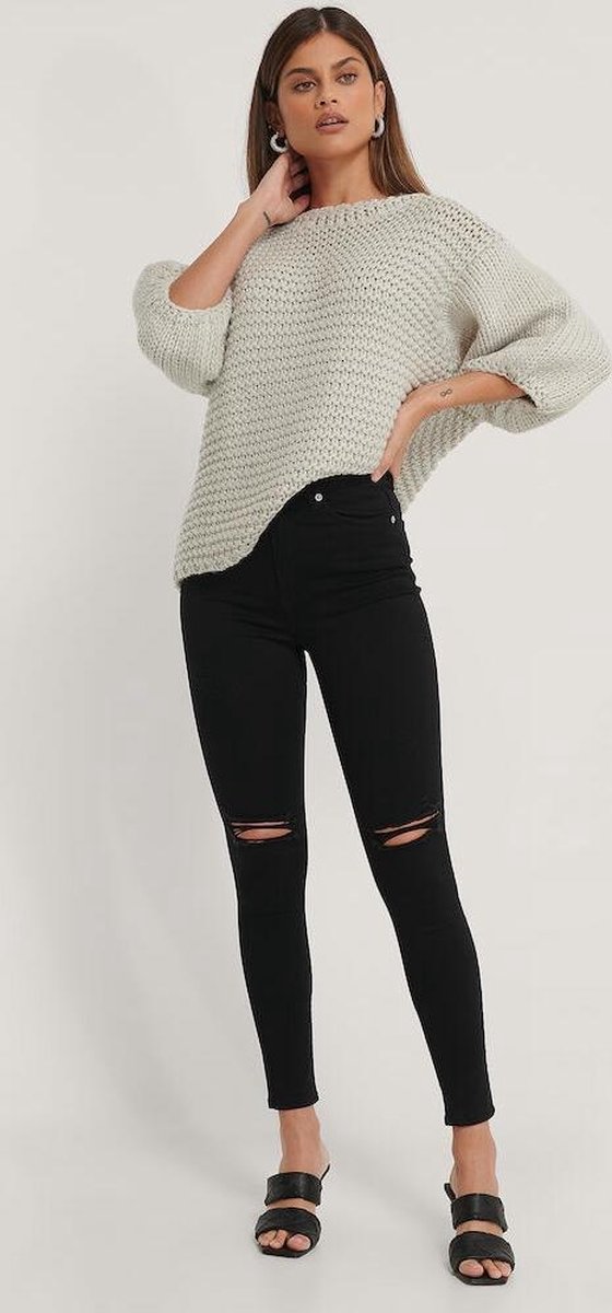 grof gebreide trui, luchtdoorlatende mouwen, zwarte ripped jeans, flat sandalen, neutrale kleur